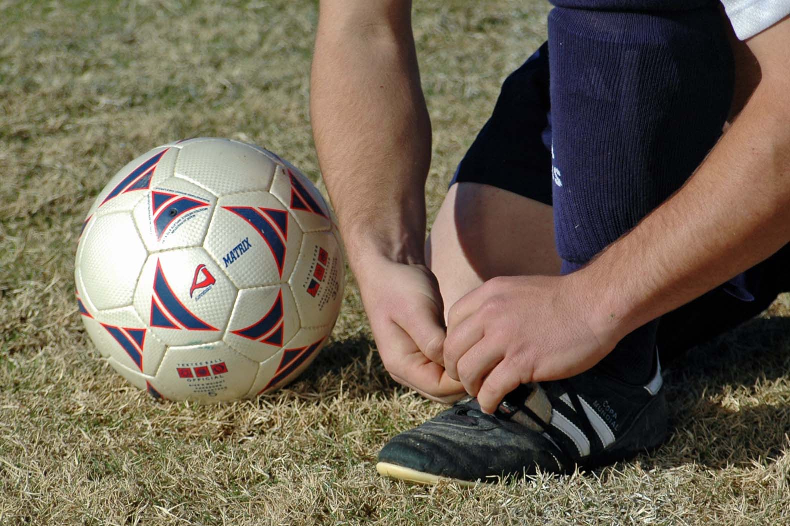DSC_0146-min Youth soccer player tying shoe.