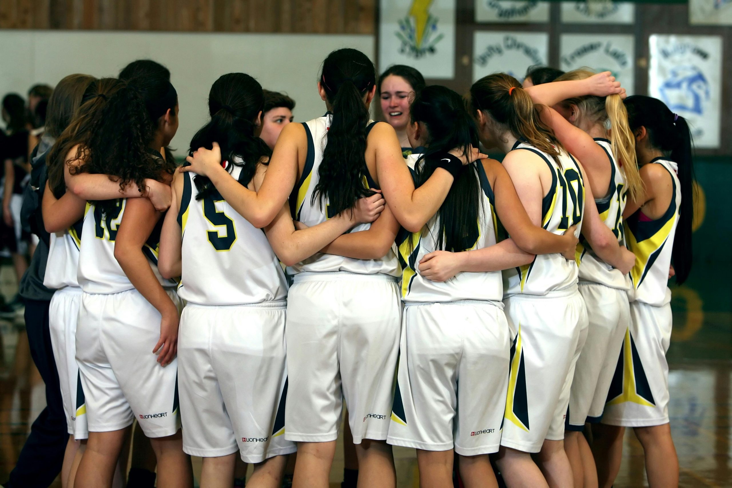pexels-pixabay-159812-min Youth basketball team huddled together.